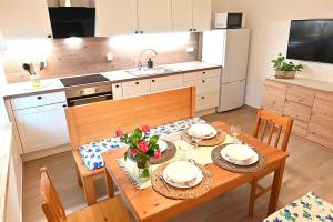 a kitchen with a wooden table with plates and flowers on it at Chalupa U lípy in Horní Bělá