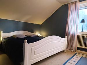 a bedroom with a large bed with a black wall at Hus Fee in Fredriksberg