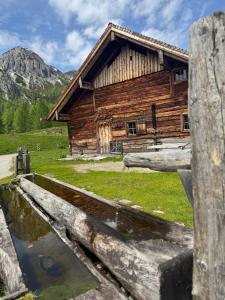 a log cabin with a pond in front of it at Grossbergblick in Filzmoos