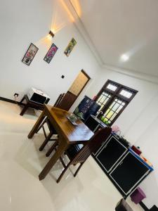 a living room with a wooden table and chairs at Woori House in Kamburugamuwa