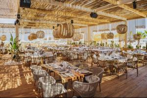 a dining room with tables and chairs and lights at Apartments complex Breeze Sunny beach - Апартаменти комплекс Бриз Слънчев бряг in Sunny Beach