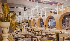 a restaurant with white tables and chairs and chandeliers at Apartments complex Breeze Sunny beach - Апартаменти комплекс Бриз Слънчев бряг in Sunny Beach +27 photos