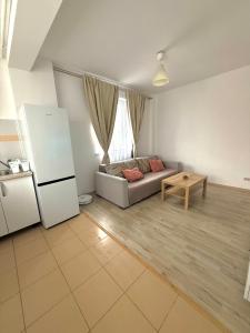 een woonkamer met een bank en een tafel bij Cozy 2Rooms in Popeşti-Leordeni +2 foto's