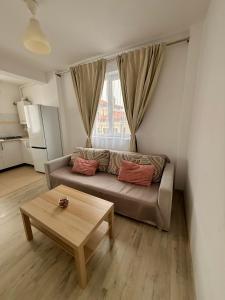 een woonkamer met een bank en een salontafel bij Cozy 2Rooms in Popeşti-Leordeni