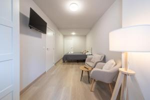 een kamer met een bed en twee stoelen en een lamp bij Apartamentos muralla de Lugo in Lugo