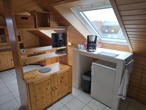 a small kitchen in a small house with a window at Ferienwohnung Auf der Warthe in Florstadt
