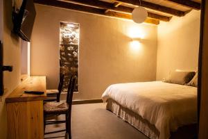 a bedroom with a bed and a desk and a chair at Vevi Villas in Vévi