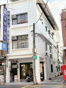 een wit gebouw op de hoek van een straat bij Jian Guo Hotel in Pingtung City