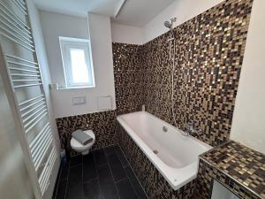 bagno con vasca e servizi igienici di Spacious Flat with 3 bedooms for 5-8 guests a Zeitz