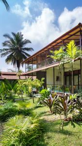 a building with a palm tree in front of it at Discovery Village Kabini in Antarasante