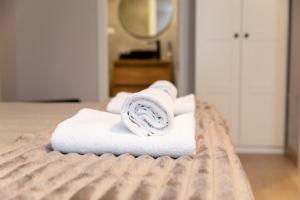 een stapel handdoeken bovenop een bed bij Apartamentos muralla de Lugo in Lugo +74 foto's