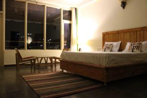 a bedroom with a bed and a table and a window at Maverick HomeStay in Baragrān +7 photos