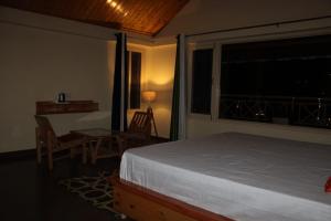 a bedroom with a bed and a table and a window at Maverick HomeStay in Baragrān
