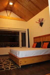 a bedroom with a wooden bed with a large window at Maverick HomeStay in Baragrān