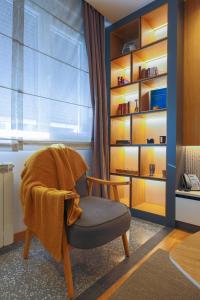 a chair sitting in a room with a book shelf at Mia's Modern Mountain in Kolašin