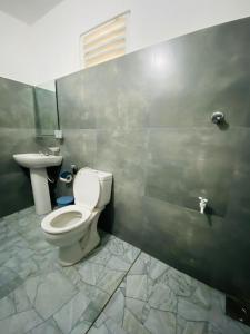 a bathroom with a toilet and a sink at m&s villa in Weligama