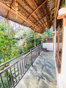 a balcony of a house with a wooden roof at m&s villa in Weligama