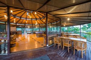 a restaurant with wooden tables and chairs on a deck at Discovery Village Kabini in Antarasante