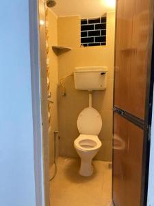 een kleine badkamer met een toilet en een raam bij Messianic guest house in Arambol