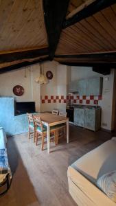 a kitchen with a table and chairs in a room at Mansarda 2 in Commezzadura