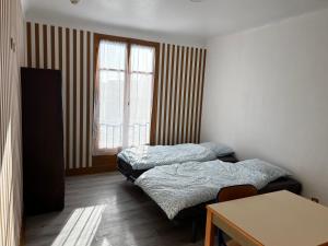 a room with two beds and a table and a window at Alpazur in Nice
