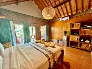een slaapkamer met een groot bed in een kamer bij Sunny Rose Bungalows Gili Air - Adults Only in Gili Air +55 foto's
