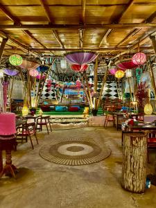 een kamer met tafels en parasols die aan het plafond hangen bij Sunny Rose Bungalows Gili Air - Adults Only in Gili Air