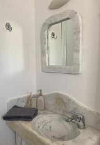 a bathroom with a sink and a mirror at Katastega Tinos in Istérnia