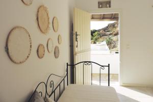 a bedroom with a bed and mirrors on the wall at Katastega Tinos in Istérnia