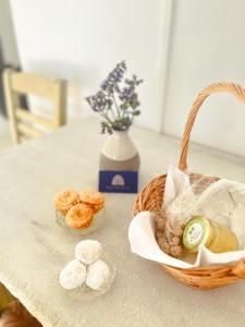 a table with a basket of pastries and a vase with flowers at Katastega Tinos in Istérnia