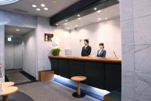 two people sitting at a bar in a lobby at Kuretake Inn Asahikawa in Asahikawa