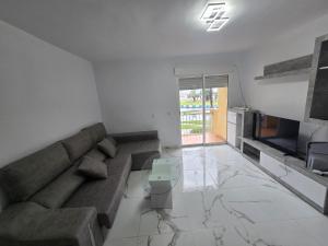 a living room with a couch and a television at Bellavista in La Línea de la Concepción