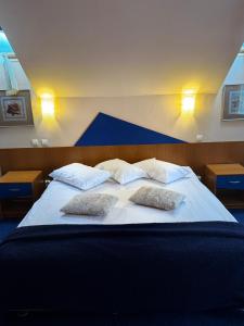 a large bed with two pillows on top of it at Vila Daria in Poiana Brasov +26 photos