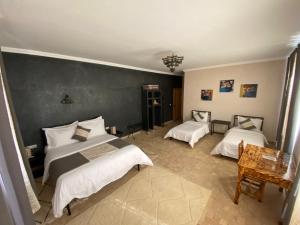 a bedroom with two beds and a green wall at Itrane sahara Auberge in Taouz +26 photos