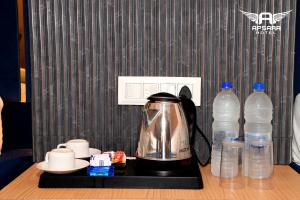 a coffee maker on a tray next to bottles of water at Hotel Apsara in Ujjain