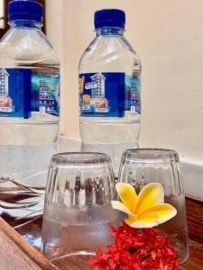 two bottles of water and two glasses and a flower at Sudi Guest House in Pemuteran +59 photos