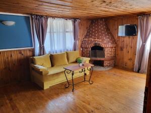 a living room with a couch and a brick fireplace at Old House - Стара Къща in Koprivshtitsa
