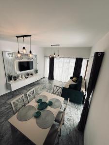 ein Wohnzimmer mit Tisch, Stühlen und Sofa in der Unterkunft Complex Brădișor in Malaia