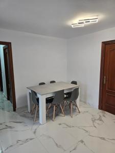 a dining room with a table and chairs on a marble floor at Bellavista in La Línea de la Concepción +3 photos