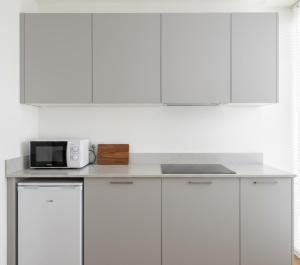 a kitchen with white cabinets and a microwave on a counter at Norvia Otel in Konya +13 photos