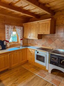 a kitchen with wooden cabinets and a stove top oven at Bioblockhaus Katschberg in Katschberghöhe