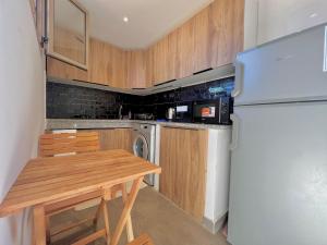 a kitchen with a wooden table and a refrigerator at Lovely studio 4th floor No Elevator in El Gouassem