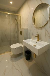 a bathroom with a sink and a toilet and a mirror at Eden Apartament-Jacuzzi, sauna in Jastrzębia Góra +23 photos