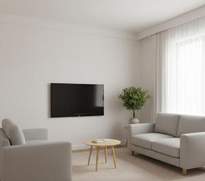 a living room with a couch and a tv on a wall at Norvia Otel in Konya