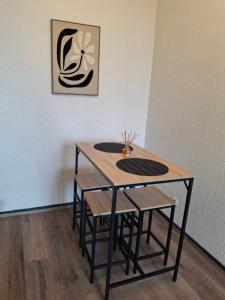 ein Tisch und Stühle in einem Raum mit einer Wand in der Unterkunft Studio petit cocon in Annonay