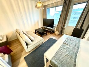een woonkamer met een bank en een tv bij DP Apartments Vaasa III in Vaasa