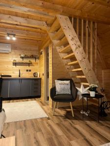 a living room with a staircase in a wooden cabin at Cottage Soul Rest in Visoko