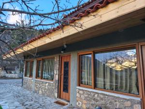 een gebouw met ramen aan de zijkant bij Φεγγαρόπετρα -ΠΑΝΣΕΛΗΝΟΣ in Kalívia