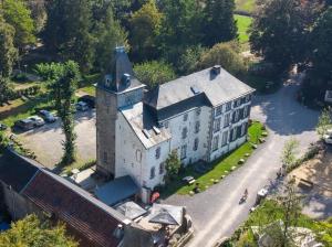 an aerial view of a large white building with a tower at Nice studio in 16th century castle in Aywaille +11 photos