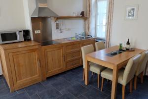 a kitchen with a wooden table and a kitchen with a microwave at Nice studio in 16th century castle in Aywaille